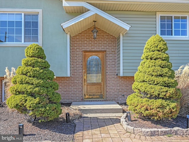 view of exterior entry with brick siding