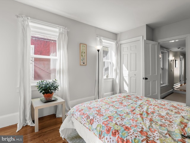 bedroom featuring a closet, baseboards, and wood finished floors