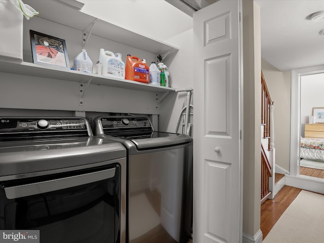 washroom with laundry area, baseboards, wood finished floors, and independent washer and dryer