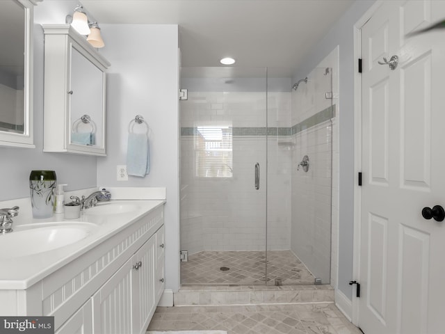 bathroom featuring double vanity, a sink, and a shower stall