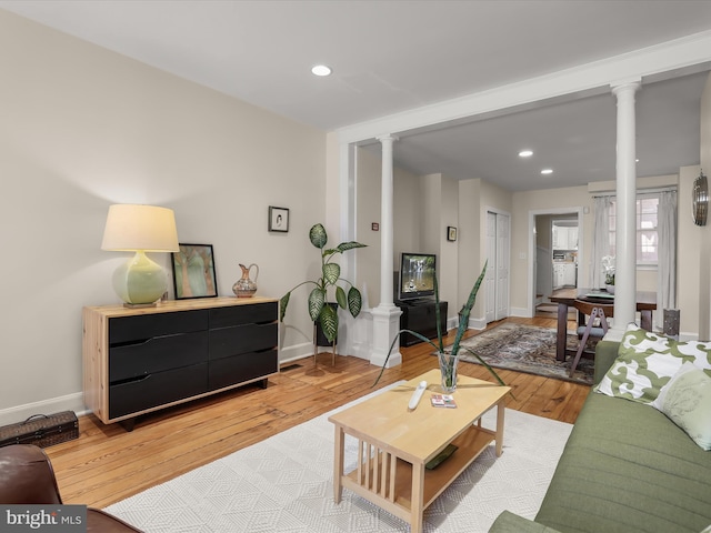 living room with ornate columns, baseboards, light wood-style floors, and recessed lighting