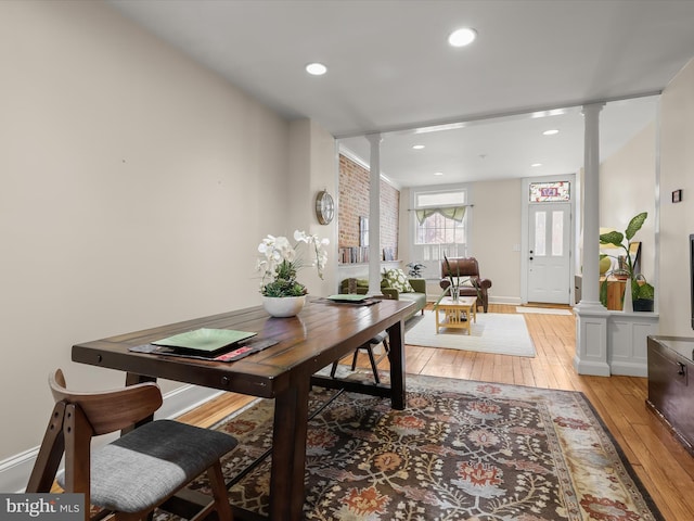 dining room with ornate columns, baseboards, light wood finished floors, and recessed lighting