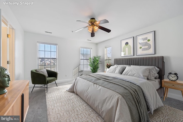 bedroom featuring ceiling fan, baseboards, and light colored carpet