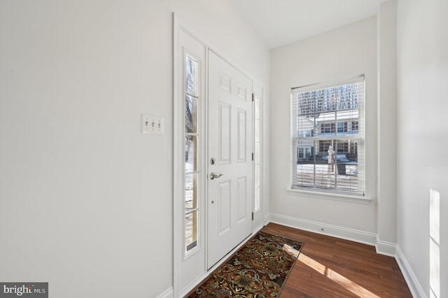 foyer entrance featuring dark wood finished floors and baseboards