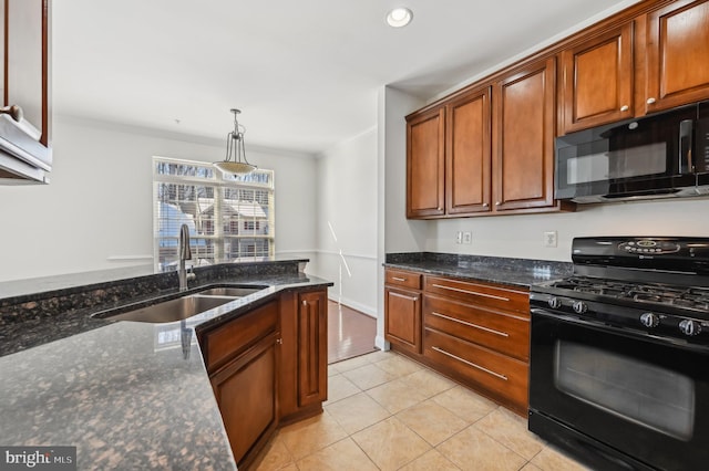 kitchen featuring light tile patterned floors, dark stone counters, hanging light fixtures, black appliances, and a sink