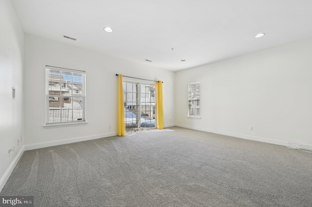 carpeted empty room featuring visible vents, baseboards, and recessed lighting