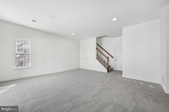 unfurnished room with recessed lighting, light colored carpet, baseboards, and stairs