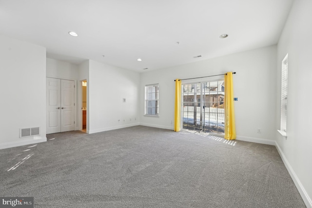 carpeted empty room featuring baseboards, visible vents, and recessed lighting