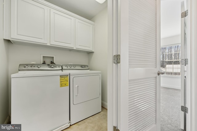 laundry room featuring washing machine and dryer, cabinet space, and baseboards