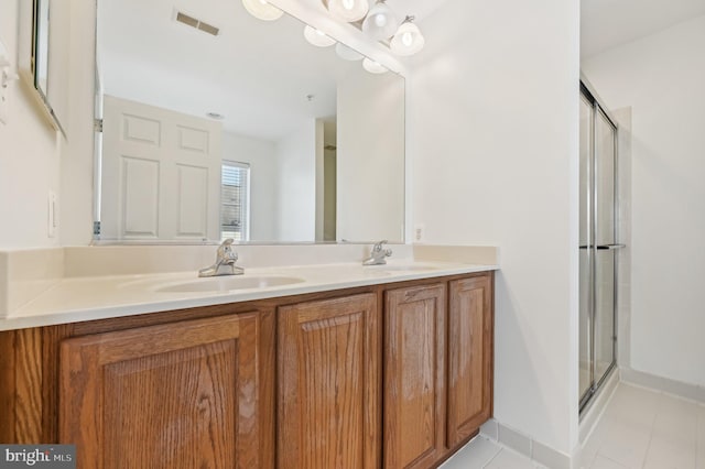 full bath with double vanity, a sink, visible vents, and a shower stall