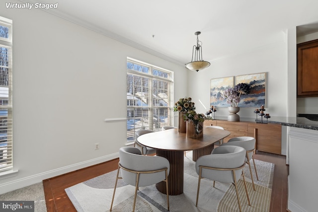 dining room featuring baseboards, dark wood finished floors, and crown molding