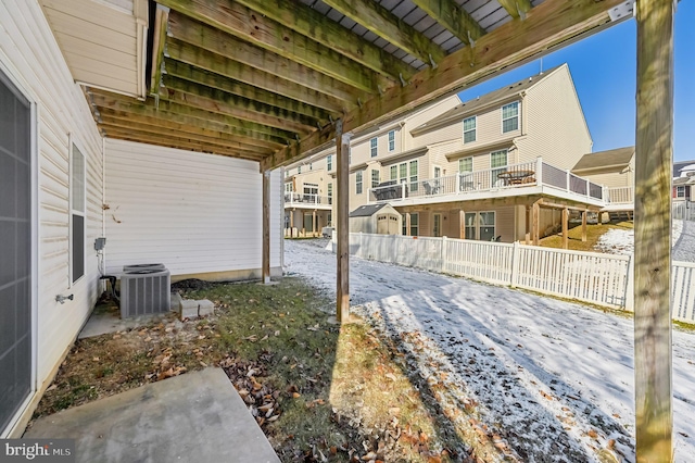 yard covered in snow with fence and central air condition unit