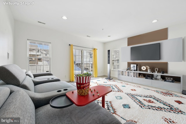 living area featuring baseboards, visible vents, and recessed lighting