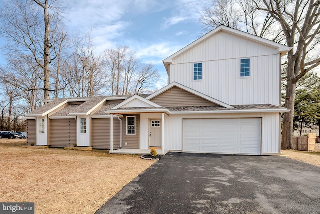 view of front of property with covered porch, roof with shingles, driveway, and an attached garage