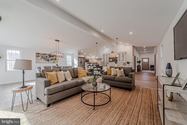 living area with baseboards, vaulted ceiling with beams, light wood-style floors, a notable chandelier, and recessed lighting