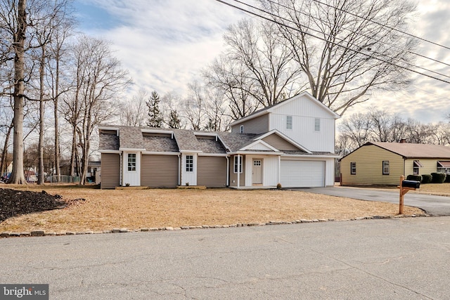 view of front facade featuring a garage, roof with shingles, and driveway