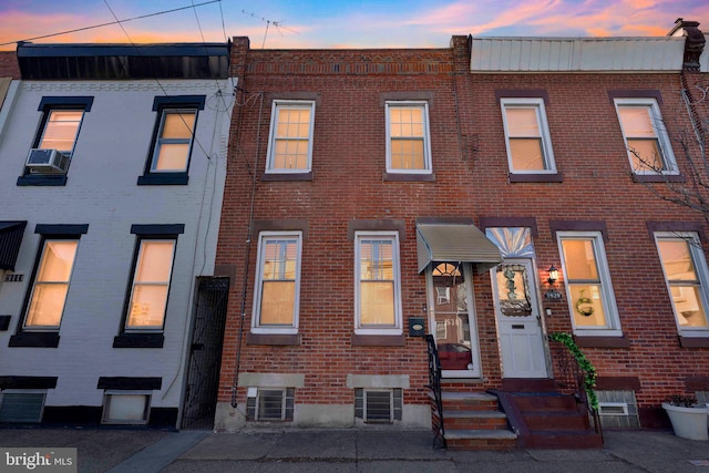 multi unit property featuring cooling unit, brick siding, and entry steps