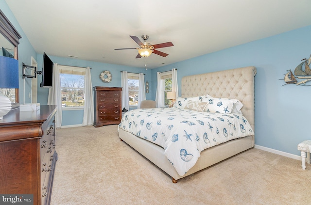 bedroom featuring light colored carpet, baseboards, and ceiling fan