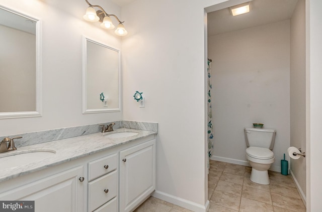 bathroom with a sink, toilet, double vanity, and tile patterned flooring