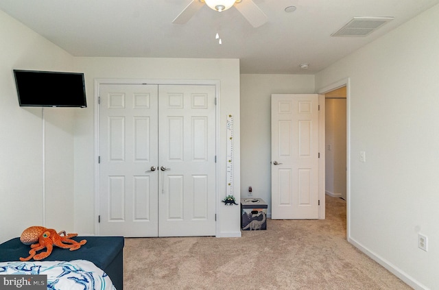 bedroom with baseboards, visible vents, carpet floors, ceiling fan, and a closet