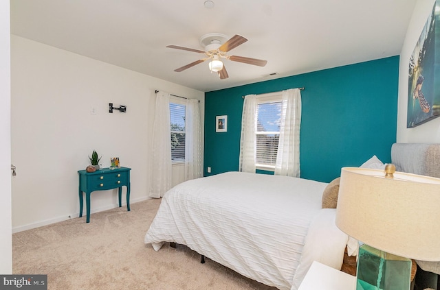 carpeted bedroom with visible vents, ceiling fan, and baseboards