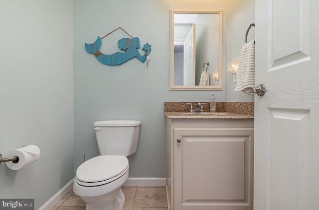 half bathroom with tile patterned floors, toilet, vanity, and baseboards