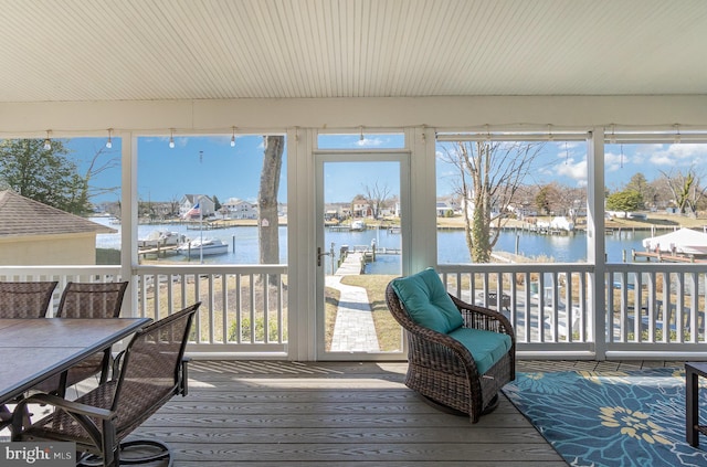 sunroom featuring a water view