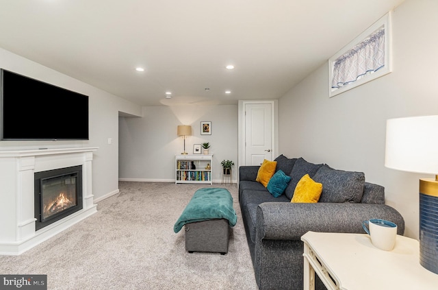 carpeted living area featuring a glass covered fireplace, recessed lighting, and baseboards