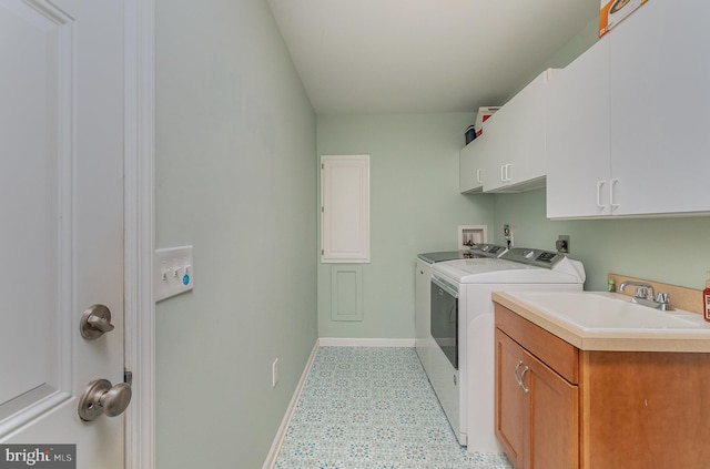 laundry area featuring washer and clothes dryer, cabinet space, baseboards, and a sink