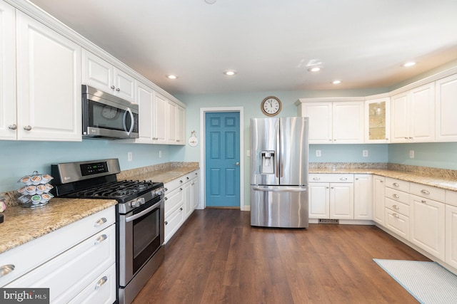 kitchen featuring dark wood finished floors, recessed lighting, stainless steel appliances, white cabinets, and light stone countertops