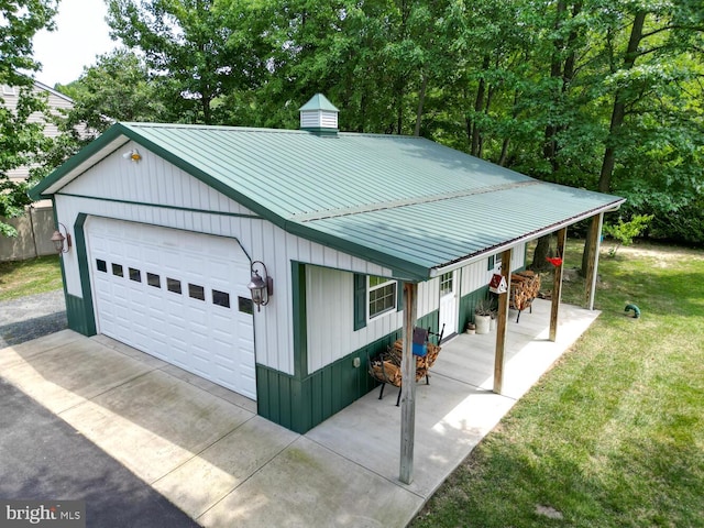 view of front facade with a front yard, metal roof, and a detached garage