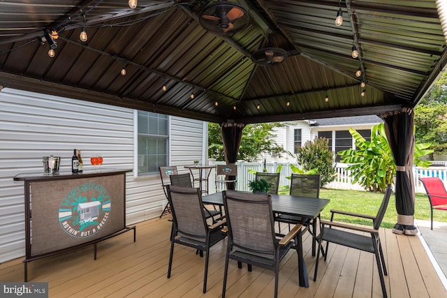 deck with a gazebo, outdoor dining space, and fence