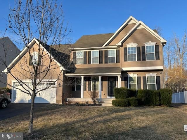 view of front of home featuring an attached garage, driveway, and fence