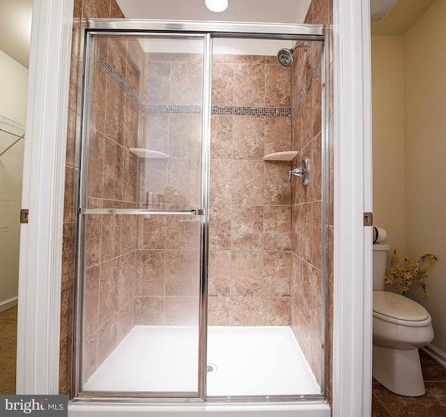 full bathroom with a shower stall and toilet