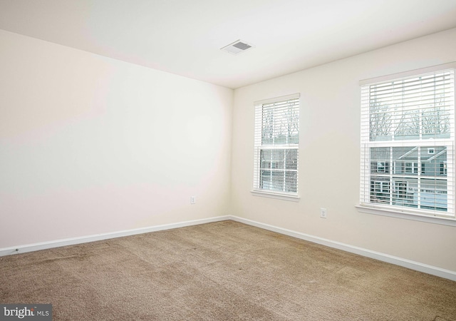 unfurnished room featuring visible vents, baseboards, and carpet flooring