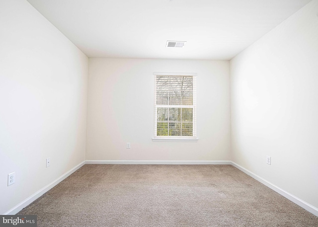 empty room featuring carpet flooring, baseboards, and visible vents