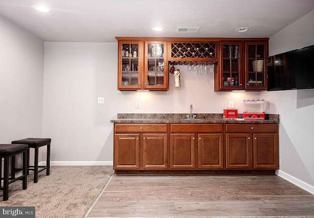 bar with baseboards, visible vents, wet bar, recessed lighting, and a sink