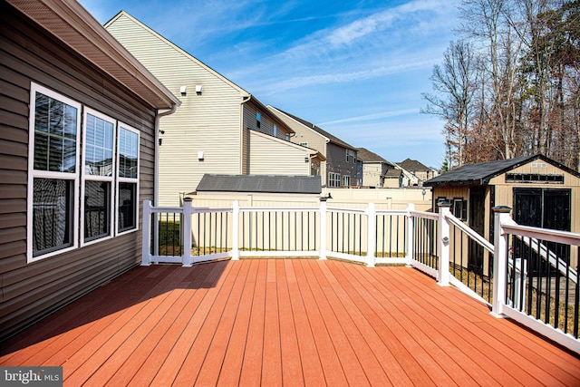 deck featuring a storage shed, an outdoor structure, and fence