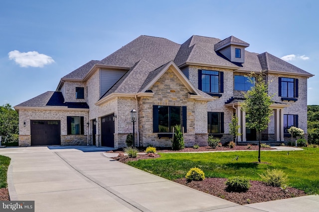 view of front of property with brick siding, a shingled roof, an attached garage, driveway, and a front lawn