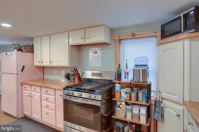 kitchen featuring stainless steel appliances, recessed lighting, light countertops, and white cabinetry