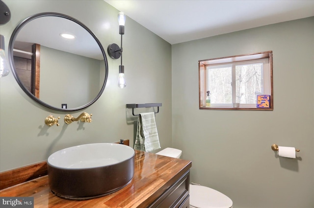 bathroom featuring toilet, wood finished floors, and vanity