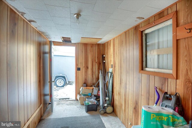 hallway featuring wooden walls