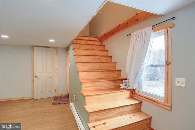 staircase with recessed lighting, a healthy amount of sunlight, baseboards, and wood finished floors