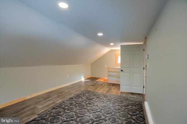 additional living space featuring baseboards, vaulted ceiling, wood finished floors, and recessed lighting