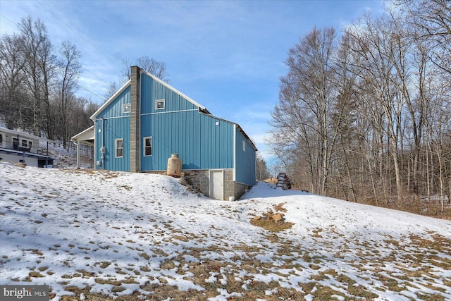 view of snow covered exterior featuring a chimney