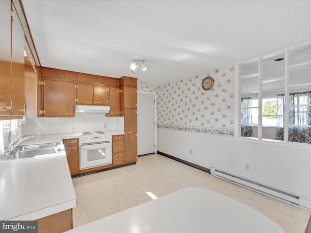 kitchen featuring light countertops, under cabinet range hood, baseboard heating, and wallpapered walls