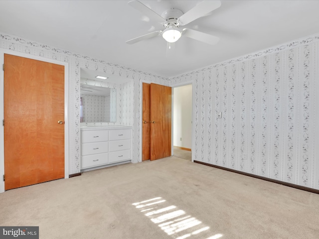 unfurnished bedroom with light carpet, wallpapered walls, ceiling fan, and baseboards