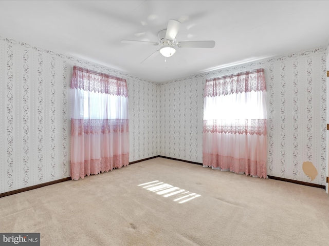 empty room with wallpapered walls, baseboards, a wealth of natural light, and carpet flooring