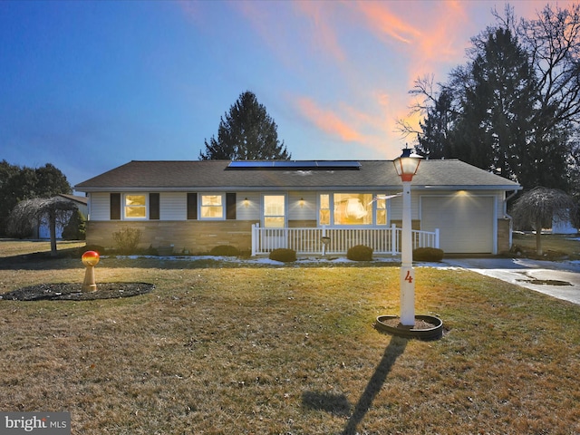 ranch-style house with a yard, driveway, a porch, and an attached garage