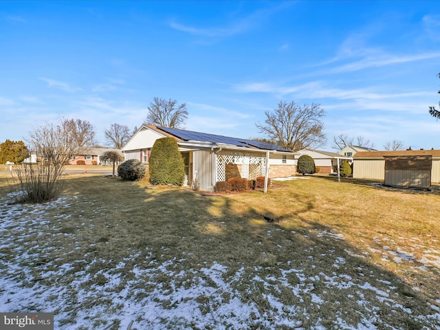 view of side of home with an outbuilding, metal roof, and a lawn